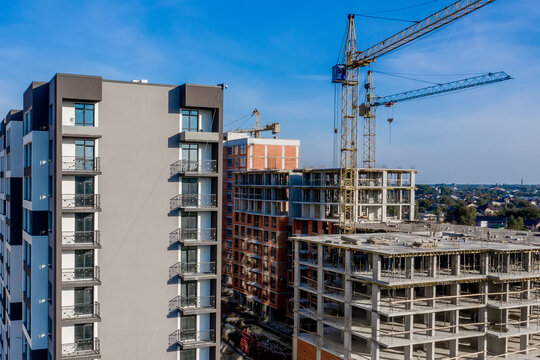 Aerial view of concrete frame of tall apartment building under construction in a city.
