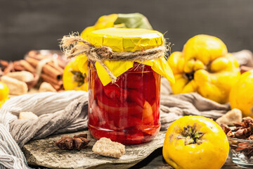 Quince jam or confiture brewed with brown sugar. Ripe whole fruits, sweet dessert, fragrant spices