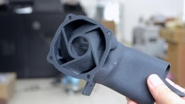 Man holding plastic model printed on powder 3d printer from polyamide powder.
