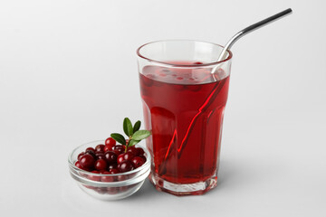 Glass with healthy cranberry juice on light background