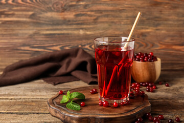 Glass with healthy cranberry juice on wooden background