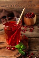 Glass with healthy cranberry juice on wooden background