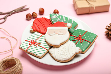 Plate with delicious Christmas cookies on color background