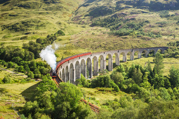Jacobite steam train on Glenfinnan Viaduct approaching, Highlands, Scotland, United Kingdom