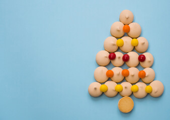 Christmas tree made of cookies and sweets on a blue background with space for text. Christmas baking concept.