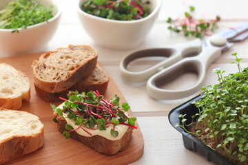 Toasts with microgreens on the table. Preparing breakfast at home. Healthy food, vegan food and dieting concept