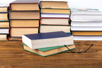 Books and glasses on a wooden table.