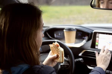 Fotobehang Drive-in lunch woman sitting car eating take away coffee © karinabost