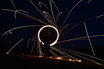 Iron wool circle drawing light fireworks. Burning Steel Wool spinning, Trajectories of burning sparks at night. Movement light effect, steel wool fire hoop. long exposure light painting, Pyrotechnic
