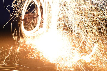 Iron wool circle drawing light fireworks. Burning Steel Wool spinning, Trajectories of burning sparks at night. Movement light effect, steel wool fire hoop. long exposure light painting, Pyrotechnic