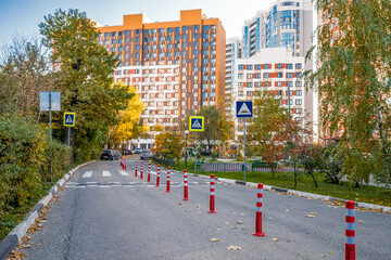 Fototapeta premium Urban development road pedestrian cross with Traffic barriers as poles, and speed dump