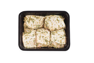 Chicken semi-cooked thighs. Raw marinated chicken thighs in sauce in a tray for a supermarket, on a white isolated background. Top of view.Raw chicken marinated.Retail.Isolated object, copy space.