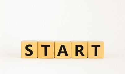 Start symbol. The concept word 'start' on wooden cubes. Beautiful white table, white background....