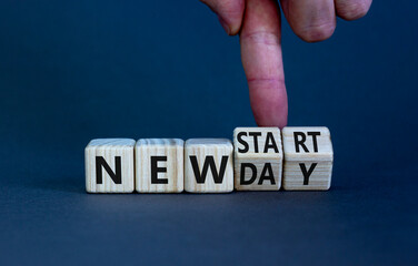 New day and start symbol. Businessman turns wooden cubes and changes words 'new day' to 'new start'. Beautiful grey table, grey background. Copy space. Business, new day and start concept.