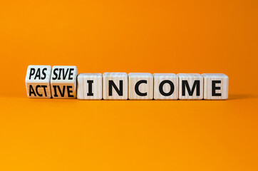 Passive or active income symbol. Turned cubes and changed words passive income to active income. Beautiful orange background, copy space. Business, passive or active income concept.