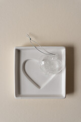 glass ornament in the shape of a heart on a square dish with a heart motif
