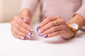 Beautiful female hands with luxury manicure nails, purple gel polish