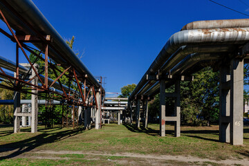 Steel pipelines outgoing from the plant at sunny day