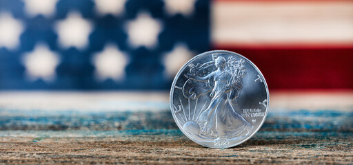 American silver eagle dollar coin with US flag in background
