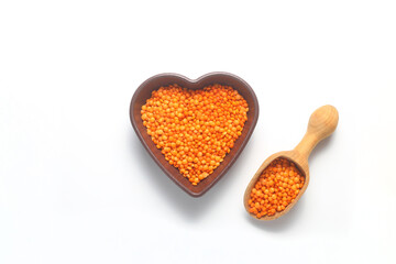 Pile red lentil in shape of heart isolated on white background. Top view. Flat lay. Vegetarian and vegan diet. High content of B vitamins in Red lentils. healthy Superfood