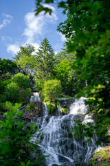 Fototapeta na wymiar Waterfall surrounded by green trees