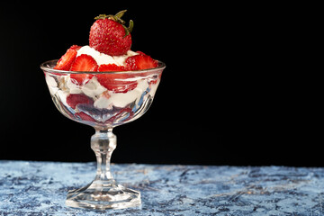 strawberry cup with cream on blue surface