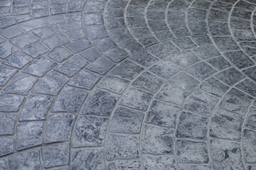 Pavement with tiles. Path paved with grey tiled stone.