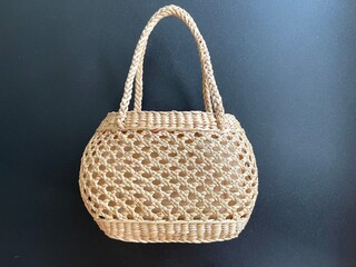 Handmade woven bag made from dried water hyacinth, weaved bag on black background