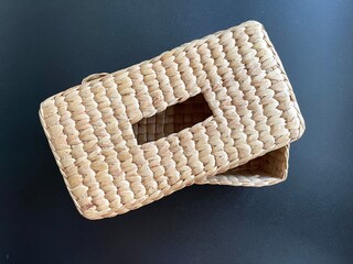 Handmade woven napkin paper box made from dried water hyacinth, woven tissue box for home use and decoration, weaved tissue paper box on black background 