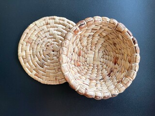 Handmade round shape basket made from dried water hyacinth, woven basket for home use and decoration, weaved basket on black background 