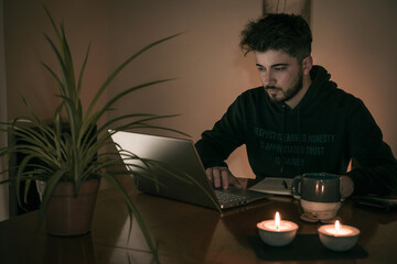 young man working / studying in front of a laptop