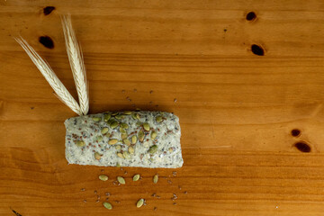 delicious bread with cereals and pistachios served for breakfast on the wooden table, dried wheat branches and pistachio seeds on the side, photo view from above.