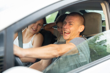 Naklejka premium Shocked family frightened of accident or collision. Man driving car during trip with his family, woman and little girl