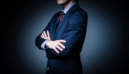 腕を組むビジネスマン　シリアスなビジネスイメージ