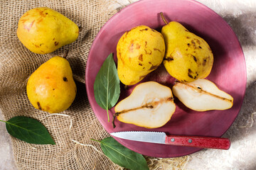 fresh pears in a dish on sacking. top view.