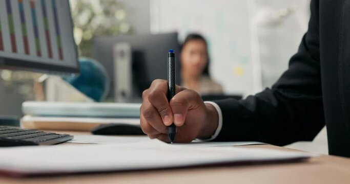 Close-up hand shot of dark-skinned man holding pen, signing documents, filling out application, cuffs of black suit, office scene, boss, manager, businessman gives consent, makes initial