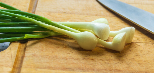 green onions on a wooden chopping board