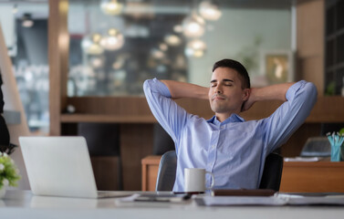 Fototapeta premium Relaxed calm caucasian businessman resting sit at office desk after working for financial with laptop computer.