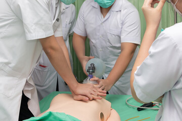 Demonstrating CPR (Cardiopulmonary resuscitation) training medical procedure on CPR doll in the class.Paramedic demonstrate first aid practice for save life.Doctor holding breathing bag(Ambu bag).