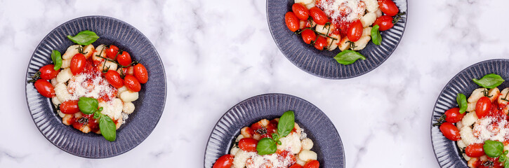 Gnocchi with tomatoes, red sauce, cheese and basil leaves