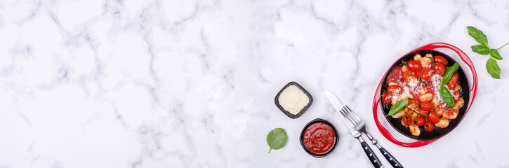 Gnocchi with tomatoes, red sauce, cheese and basil leaves