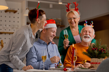 Different generation caucasian family toasting with sparkling wine celebrating Christmas or New Year during festive season at home