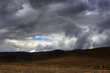 Fototapeta na wymiar Dark Cloudy Sky over Desolate Hills