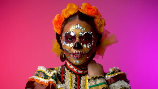 Studio close up portrait of mexican girl in folklore costume and day of the dead style make up. Mexico culture, fashion and traditions. Day of the dead 2021.