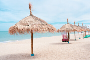 beach with umbrellas.Parasols sunbed beach clouds turquoise sea.