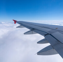 View of an airplane wing and land and sky as background.