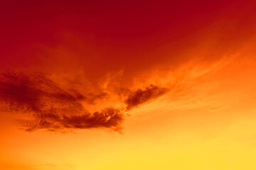 A vibrant sunset sky with shades of red, orange, and yellow. There are clouds in the sky.