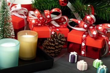 Christmas decorations with gift boxes, scented candle and marzipan sweets..