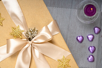 Close up of a Christmas or New Year brown gift box with champagne gold color ribbon.