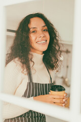 Latin woman drinking coffee in kitchen
